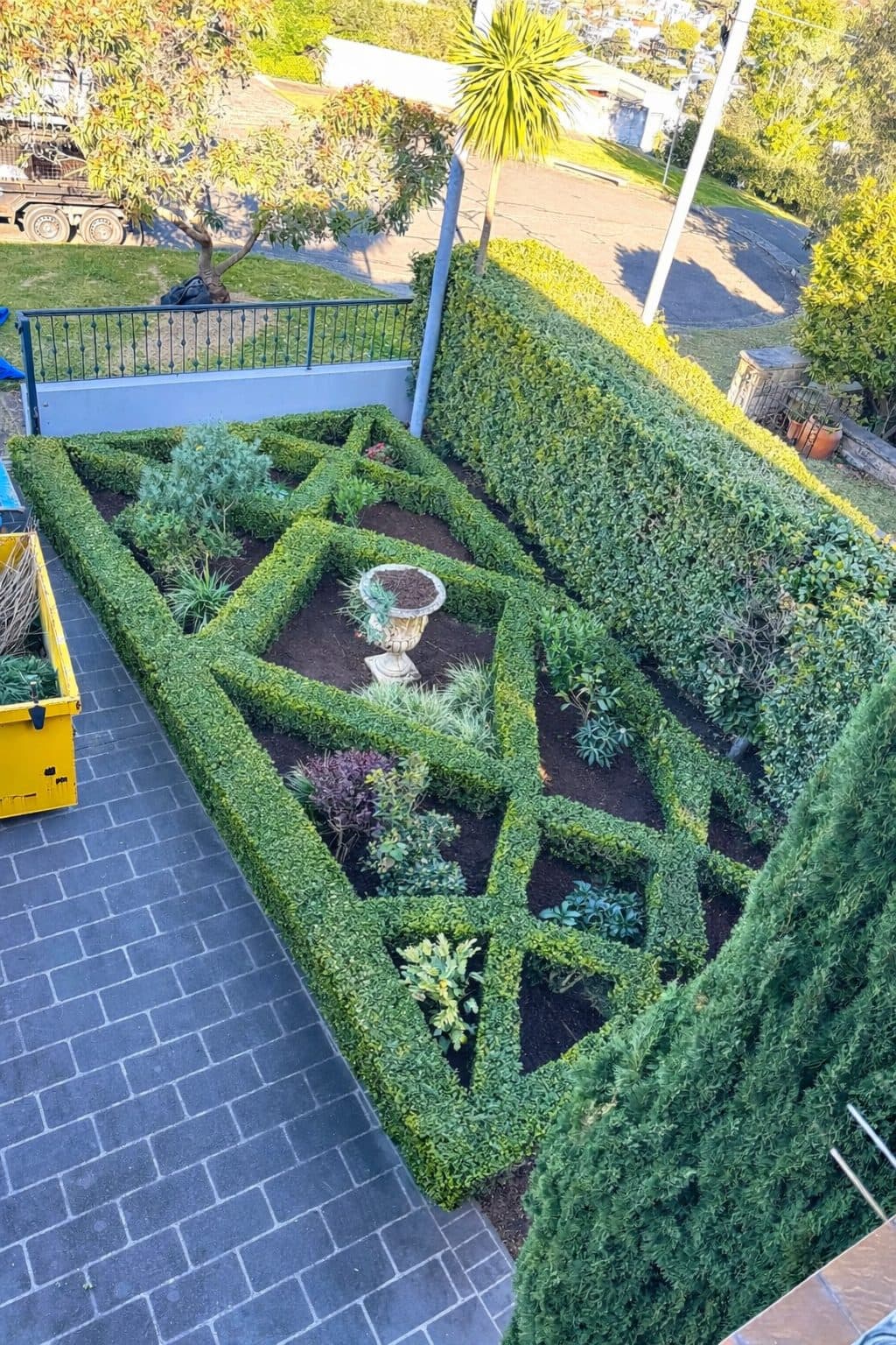 Box hedges clipped into a geometric parterre with a central urn